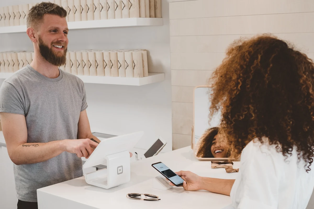 Person making a contactless credit card payment at a checkout terminal